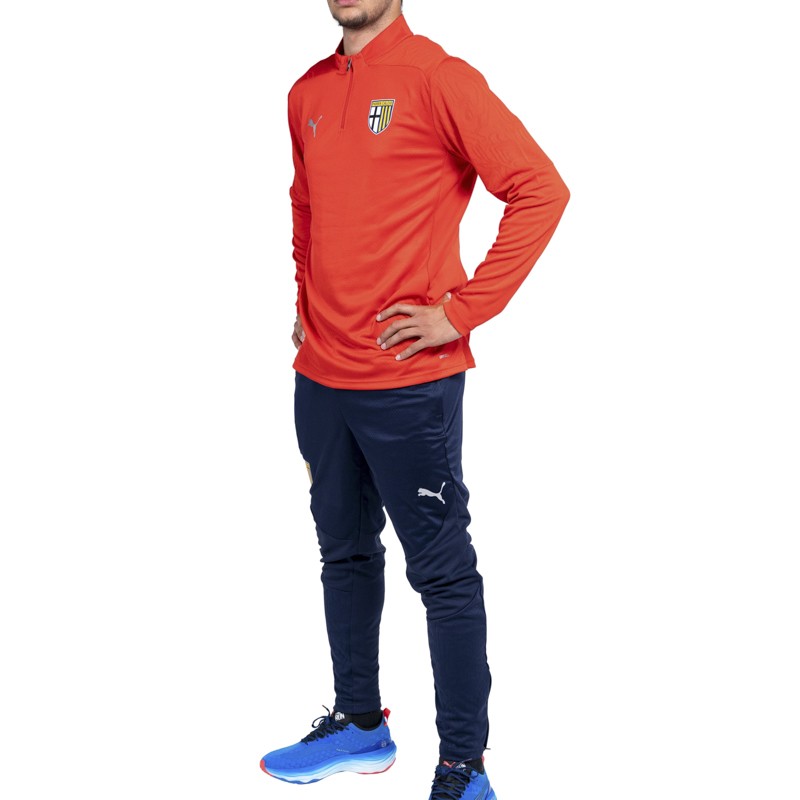 Felpa rossa training con 1/4 zip texture geometrica sulle spalle e logo Parma Calcio abbinata a pantaloni blu training