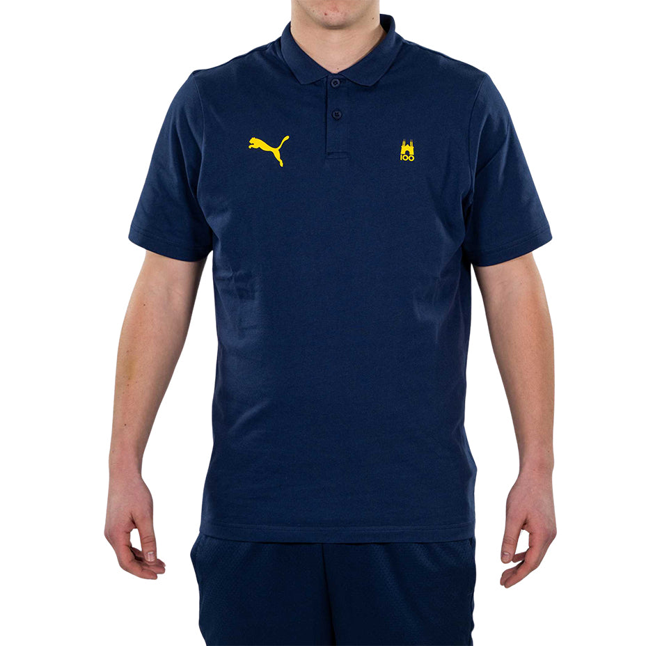 Ragazzo indossa polo blu con logo tardini 100 e puma giallo