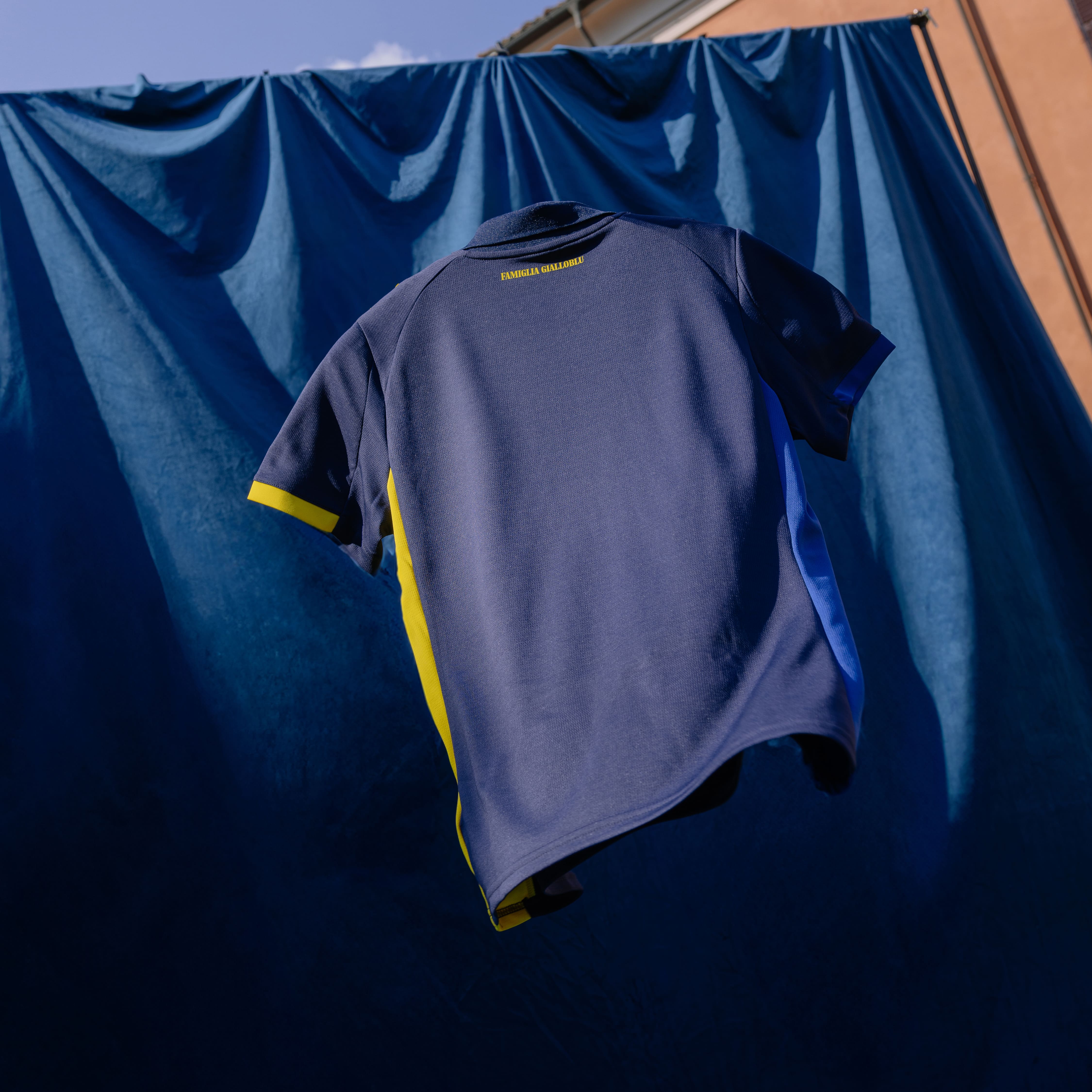 Retro maglia gara Fourth con sponsor gialli prima squadra Maschile. Maglia blu navy con colletto, dettagli laterali e dettagli maniche blu e gialli. Sul retro scritta Famiglia Gialloblu