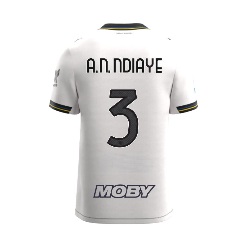 Maglia gara Junior Home Parma Calcio Warm White con croce nera colletto a V, i dettagli in blu e giallo personalizzata con nome e numero A.N. Ndiaye 3, sponsor e patch serie A