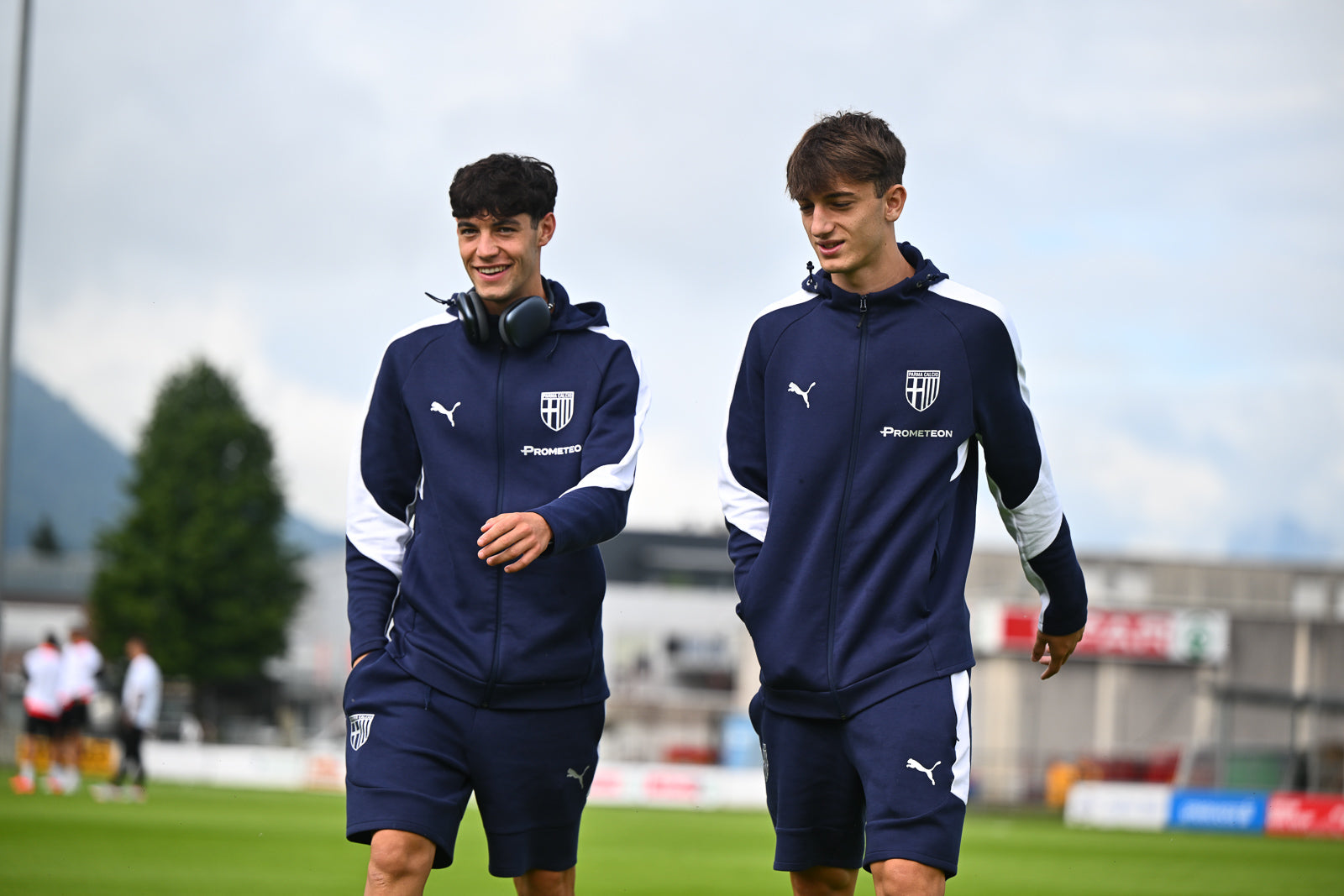 Foto prima squadra maschile Parma calcio mentre indossano t-shirt, bermuda e felpa blu navy linea Travel