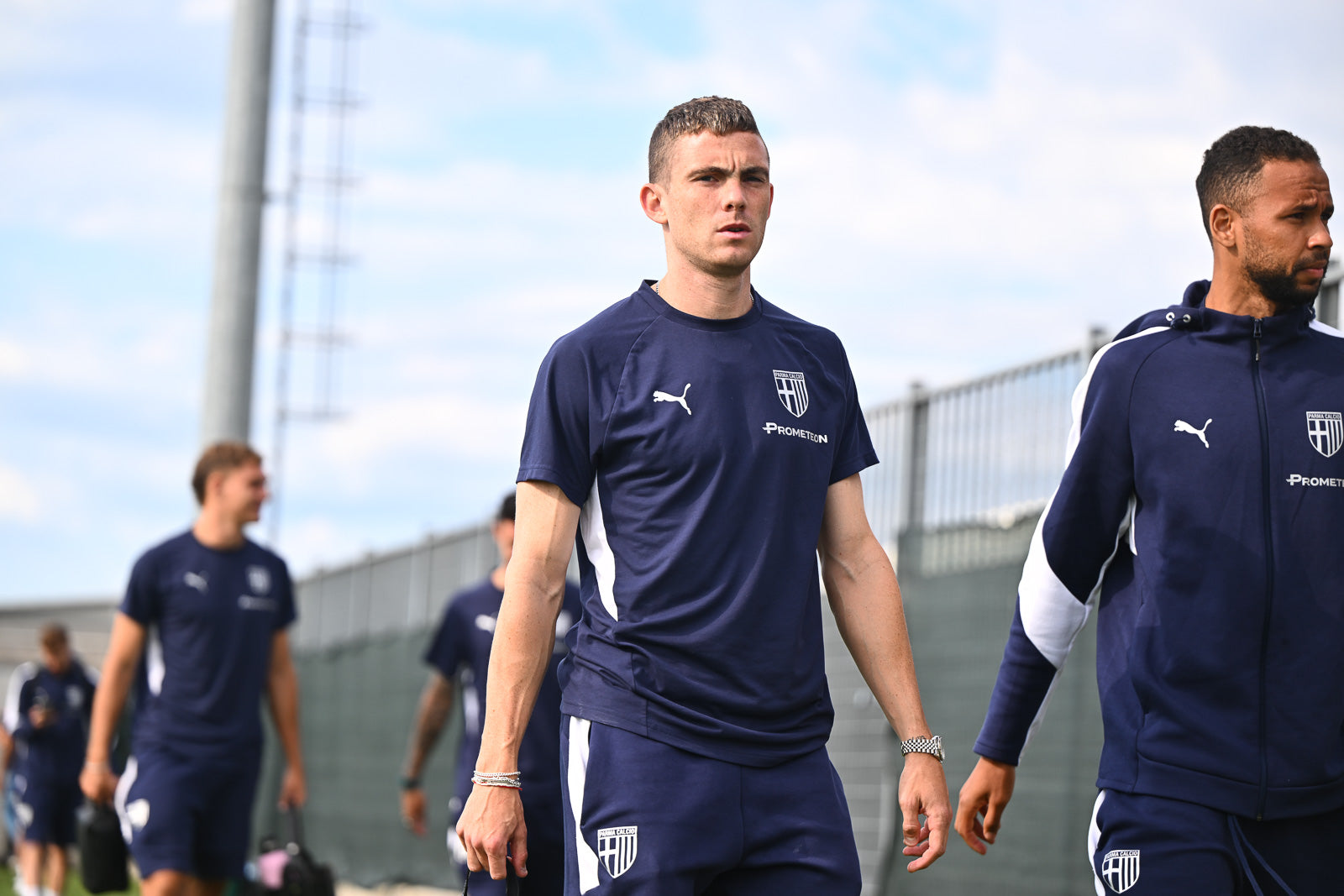 Foto prima squadra maschile Parma calcio mentre indossano t-shirt, bermuda e felpa blu navy linea Travel