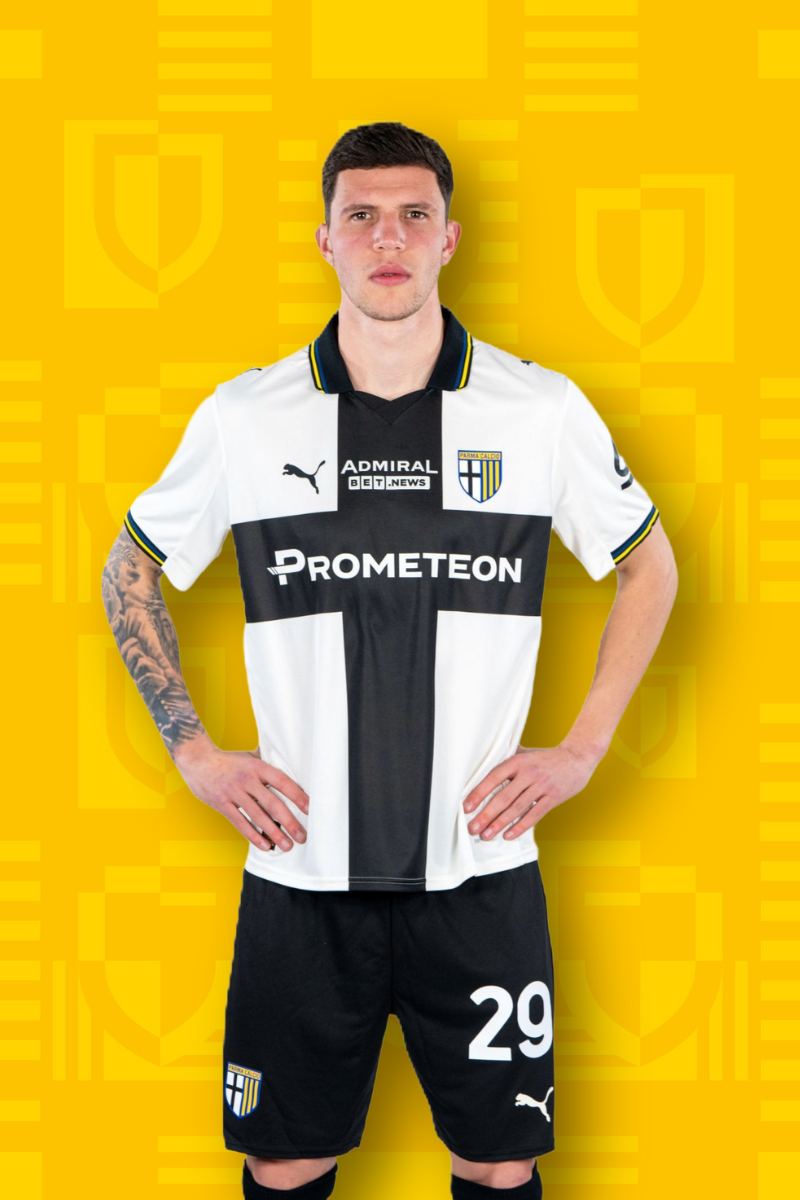 Card Calciatore Carboni 29 con maglia home binca e croce nera, pantaloncini neri e sfondo texture gialla