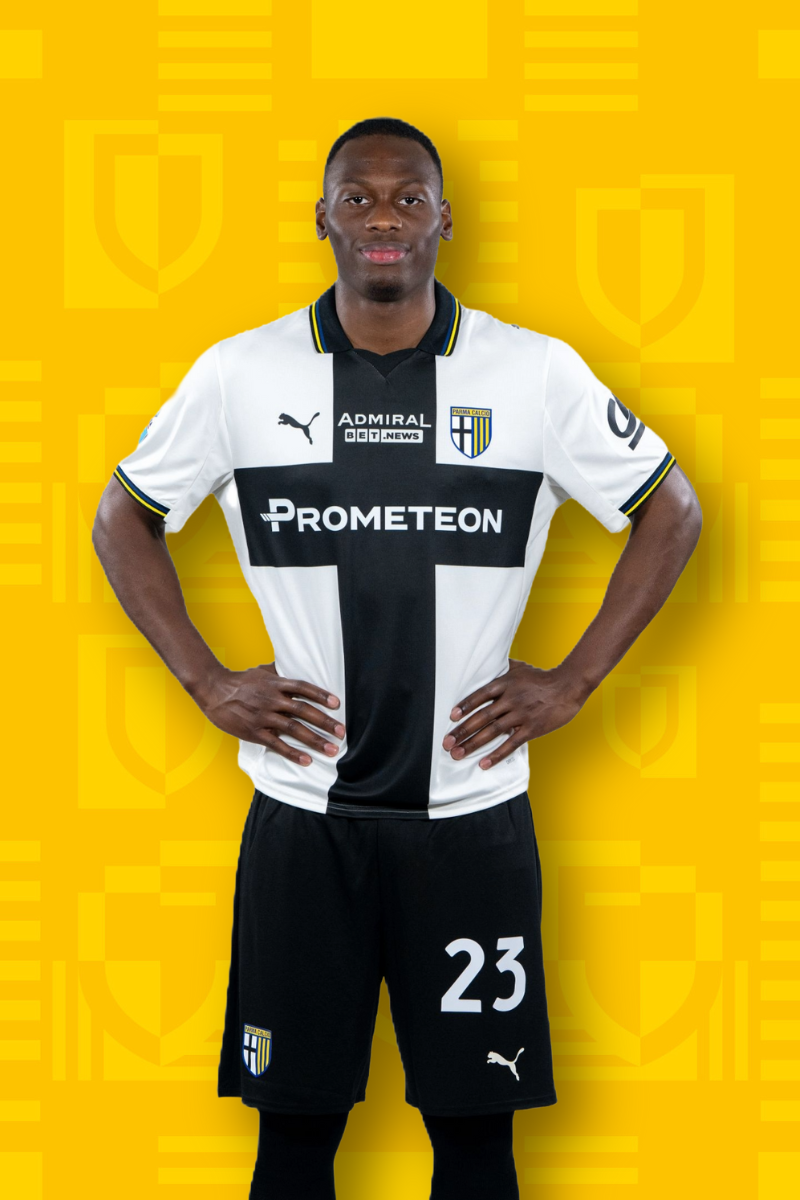 Card Calciatore Elphege 23 con maglia home binca e croce nera, pantaloncini neri e sfondo texture gialla