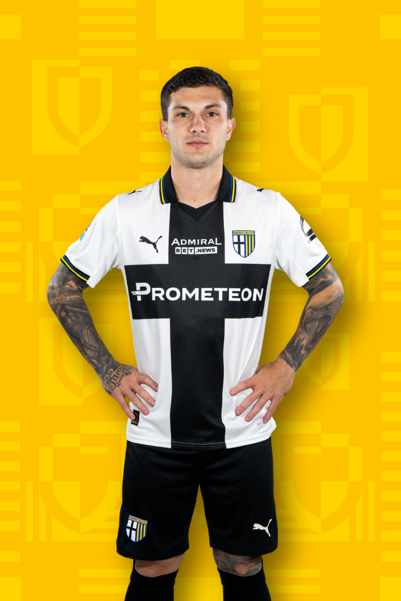 Card Calciatore Strefezza 7 con maglia home binca e croce nera, pantaloncini neri e sfondo texture gialla