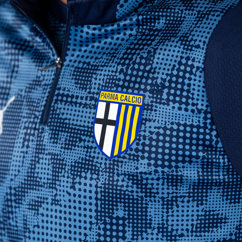 Dettaglio felpa 1/4 zip training blu navy calciatori con logo Parma Calcio su sfondo geometrico